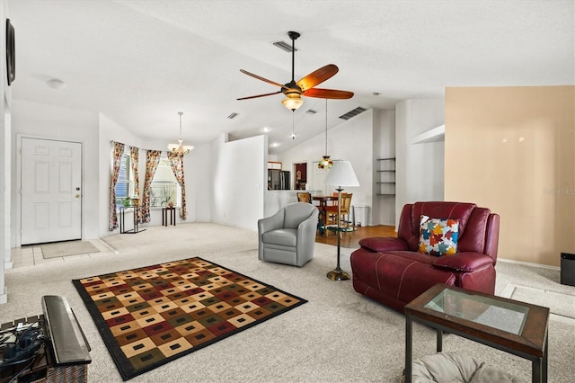 living room with ceiling fan with notable chandelier, light colored carpet, and vaulted ceiling