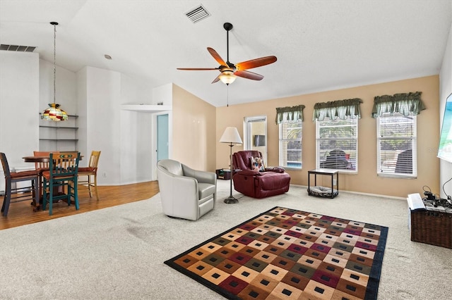 carpeted living room featuring ceiling fan and vaulted ceiling