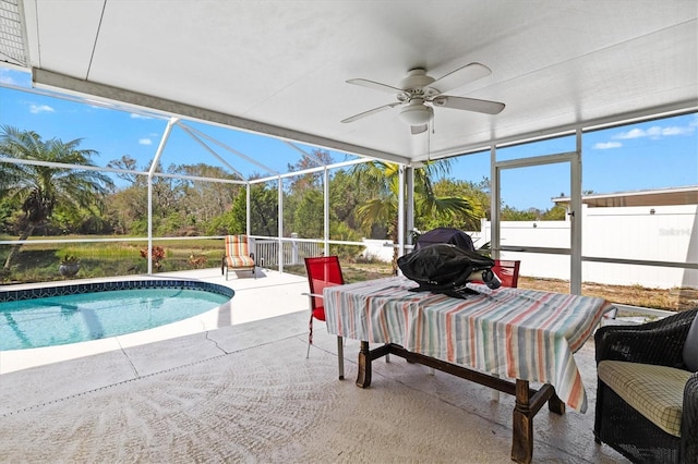 exterior space with ceiling fan, glass enclosure, and a patio area