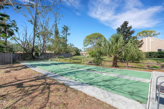 view of home's community with shuffleboard and fence