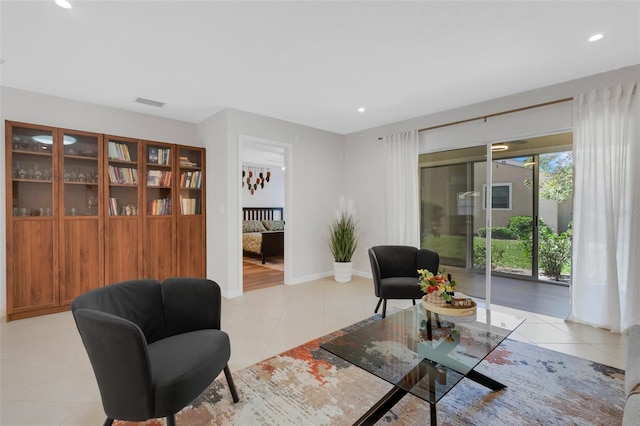 living area with light tile patterned floors, visible vents, recessed lighting, and baseboards