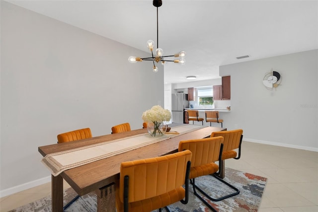 dining space with light tile patterned flooring, visible vents, a notable chandelier, and baseboards