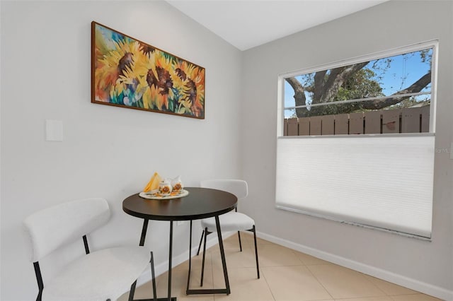 tiled dining room featuring baseboards