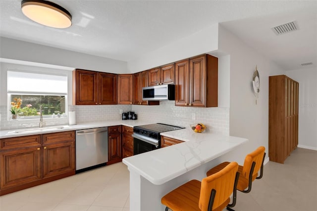 kitchen featuring visible vents, backsplash, appliances with stainless steel finishes, and a sink