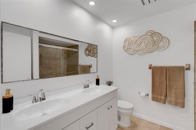 bathroom featuring toilet, a sink, tile patterned flooring, double vanity, and tiled shower