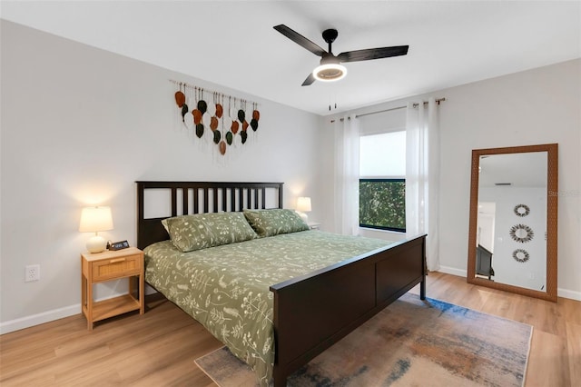 bedroom with ceiling fan, baseboards, and wood finished floors