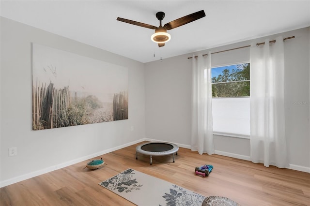 unfurnished room featuring baseboards, wood finished floors, and a ceiling fan