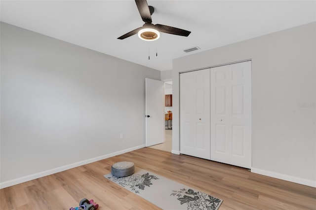 unfurnished bedroom with a ceiling fan, visible vents, baseboards, light wood finished floors, and a closet