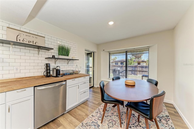 kitchen with light wood-style flooring, wood counters, stainless steel dishwasher, decorative backsplash, and open shelves