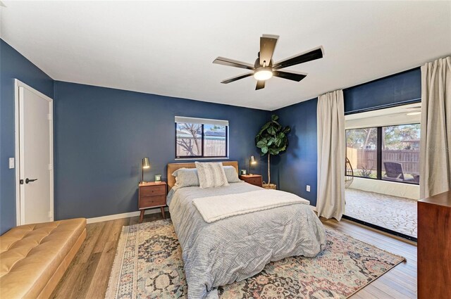 bedroom featuring multiple windows, wood finished floors, and access to exterior