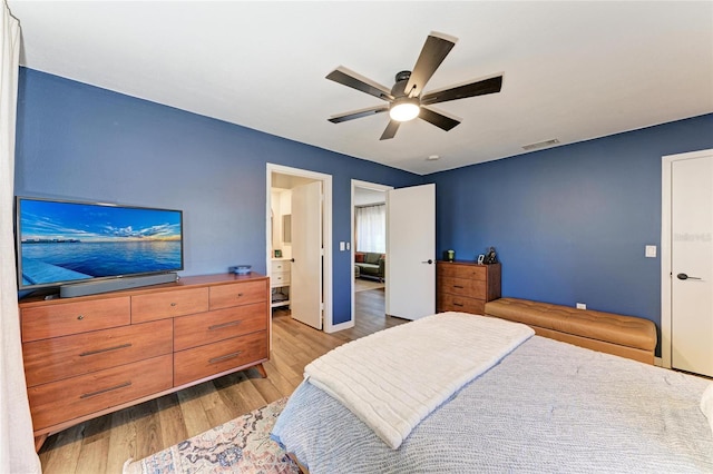 bedroom with light wood finished floors, visible vents, and a ceiling fan