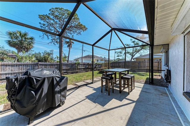 view of patio with a lanai, a fenced backyard, outdoor dining area, and area for grilling