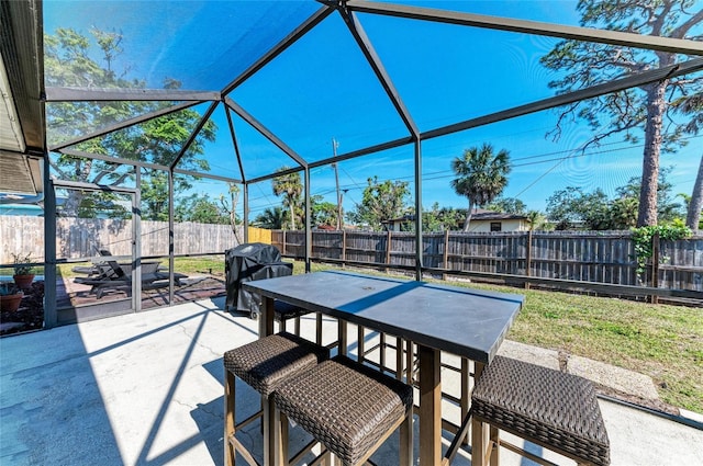 view of patio / terrace with glass enclosure, outdoor dining area, area for grilling, and a fenced backyard