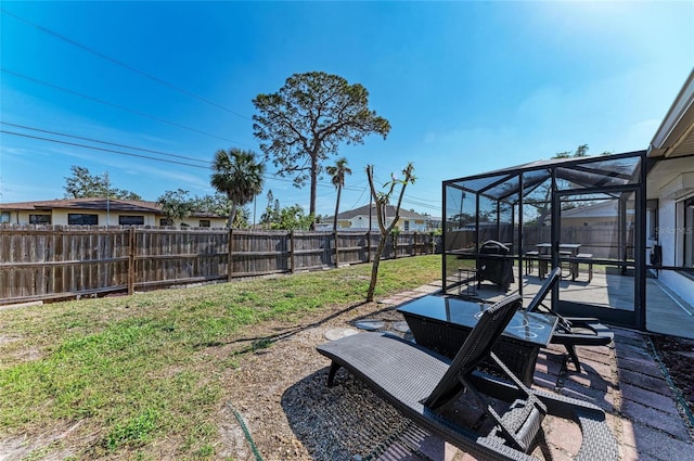 view of yard featuring glass enclosure, a patio area, and a fenced backyard