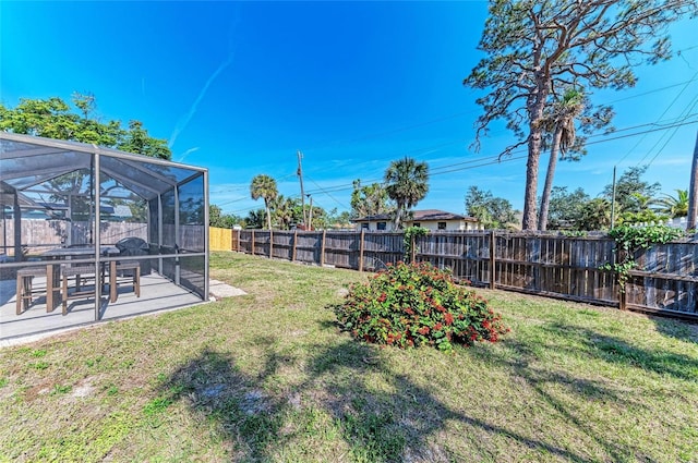 view of yard featuring glass enclosure, a patio area, and a fenced backyard