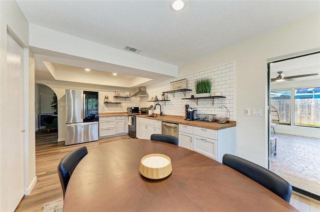 dining space with recessed lighting, visible vents, baseboards, light wood finished floors, and a raised ceiling