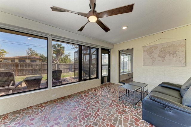 living area featuring ceiling fan, stone finish floor, and recessed lighting