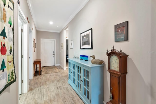 corridor with light hardwood / wood-style flooring and ornamental molding