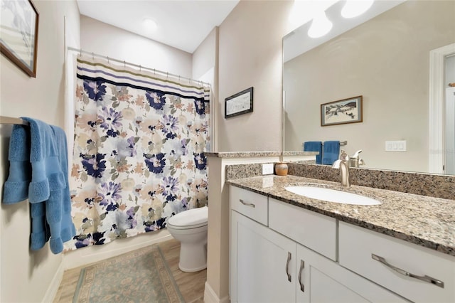 bathroom featuring vanity, toilet, and walk in shower