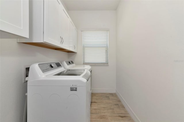laundry room featuring independent washer and dryer and cabinets