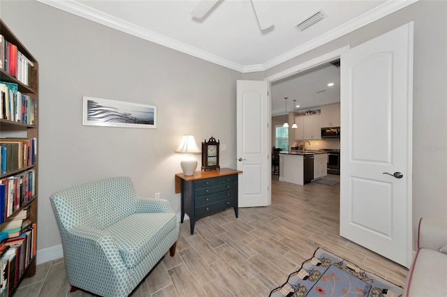 living area featuring sink, ornamental molding, and ceiling fan