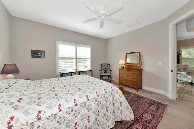 bedroom featuring multiple windows, light carpet, and ceiling fan