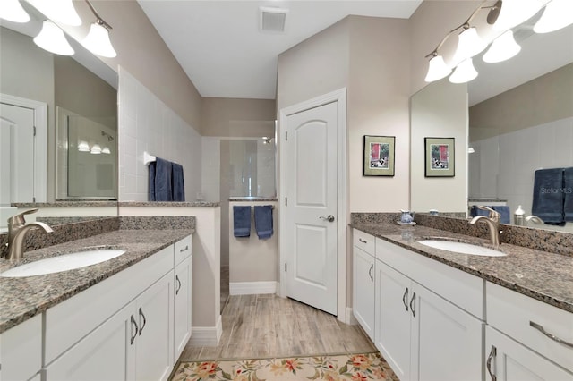bathroom with vanity, hardwood / wood-style flooring, and walk in shower