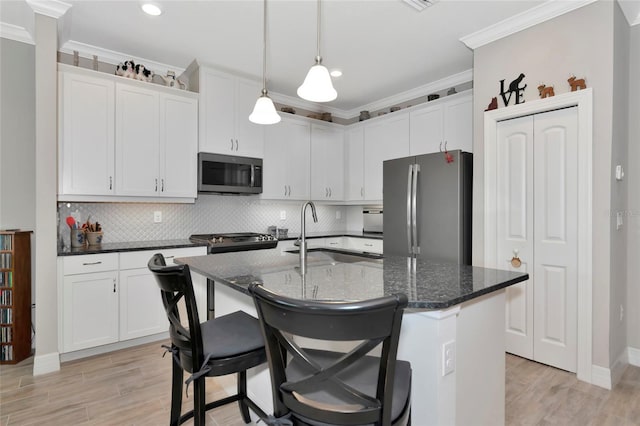 kitchen featuring a kitchen island with sink, sink, white cabinetry, and stainless steel appliances