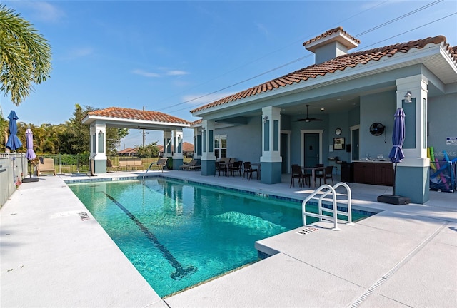 view of pool with a patio and ceiling fan