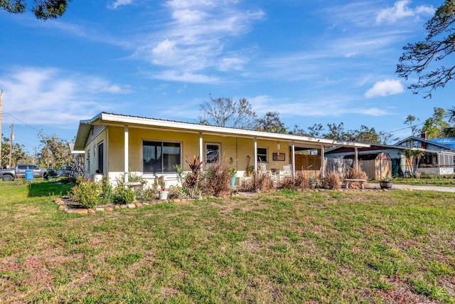 ranch-style house with covered porch, metal roof, and a front lawn