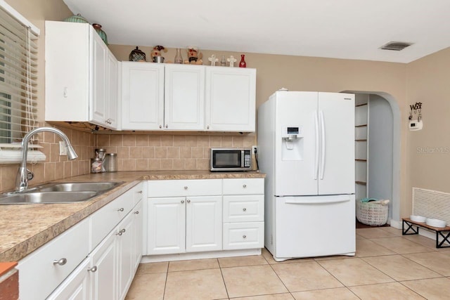 kitchen featuring stainless steel microwave, visible vents, white cabinets, a sink, and white fridge with ice dispenser