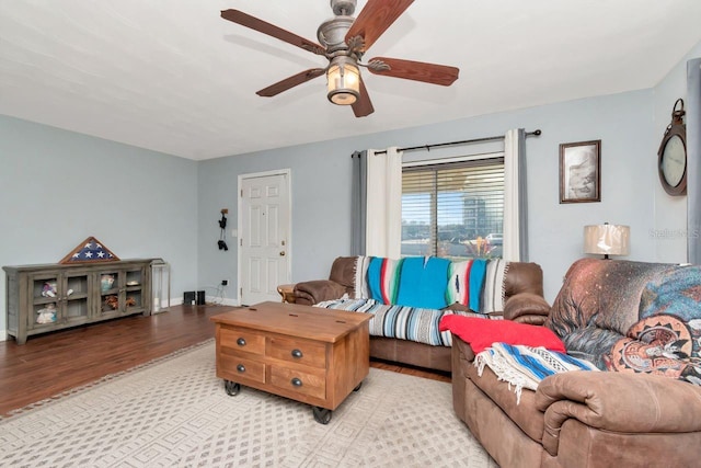 living room with baseboards, light wood-style flooring, and a ceiling fan