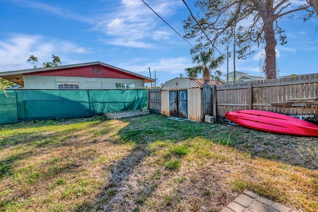 view of yard featuring an outbuilding, a storage unit, and a fenced backyard