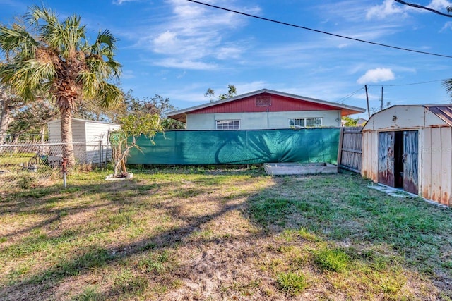 view of yard with fence, an outdoor structure, and a shed