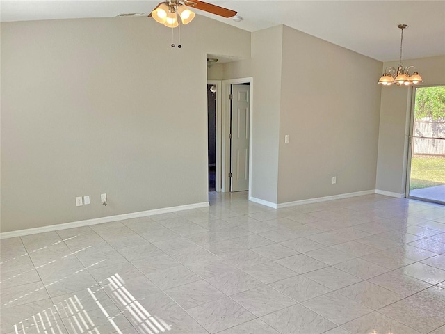 spare room with vaulted ceiling, ceiling fan with notable chandelier, and light tile patterned floors