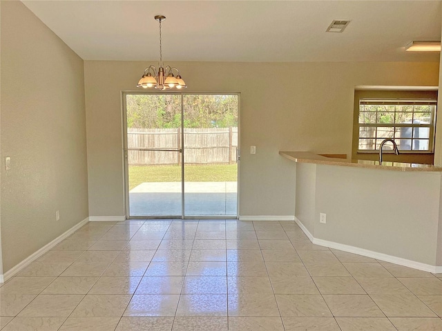 unfurnished dining area with tile patterned floors, a chandelier, and sink