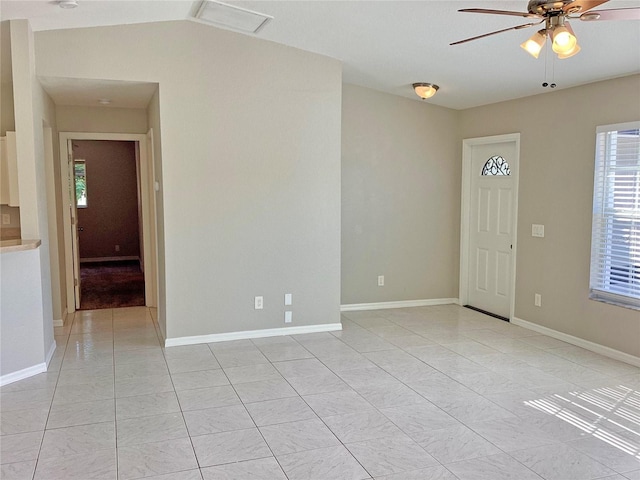 empty room featuring vaulted ceiling, ceiling fan, and light tile patterned flooring