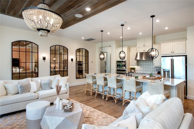 living room featuring an inviting chandelier, wood ceiling, and light hardwood / wood-style floors