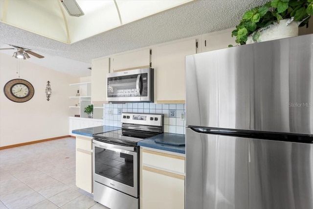 kitchen with light tile patterned flooring, backsplash, ceiling fan, stainless steel appliances, and a textured ceiling