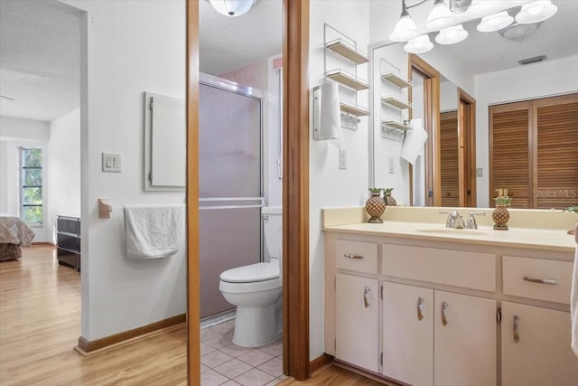 bathroom with walk in shower, toilet, wood-type flooring, a textured ceiling, and vanity