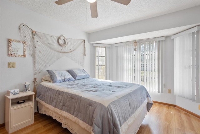 bedroom featuring ceiling fan, light hardwood / wood-style flooring, and a textured ceiling