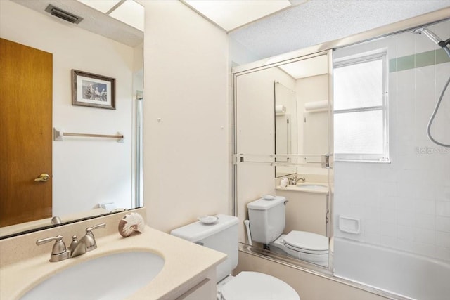 full bathroom featuring vanity, bath / shower combo with glass door, and toilet