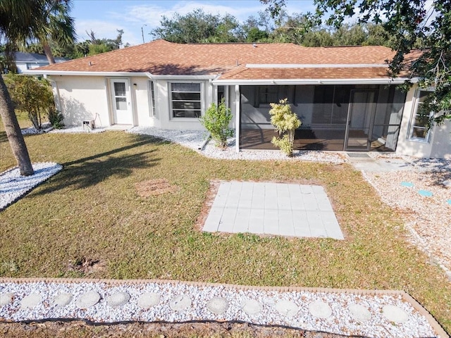 rear view of property featuring a yard and a sunroom