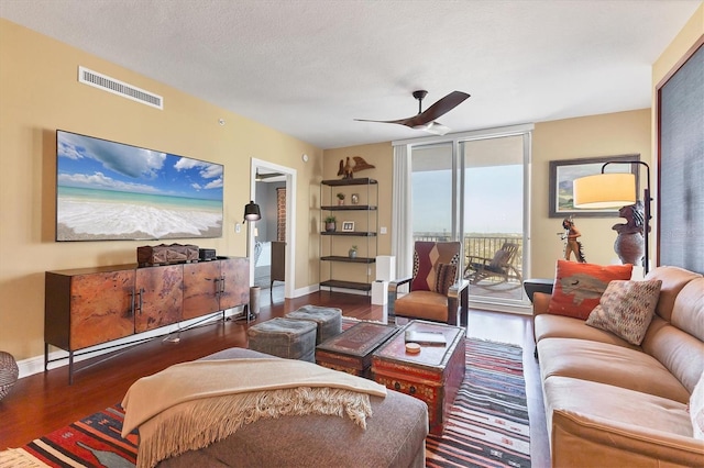 living room with expansive windows, dark wood-type flooring, a textured ceiling, and ceiling fan