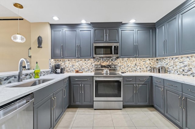 kitchen featuring appliances with stainless steel finishes, pendant lighting, tasteful backsplash, sink, and light tile patterned floors