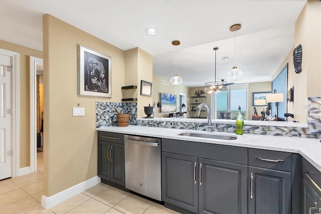 kitchen featuring sink, light tile patterned floors, hanging light fixtures, and dishwasher