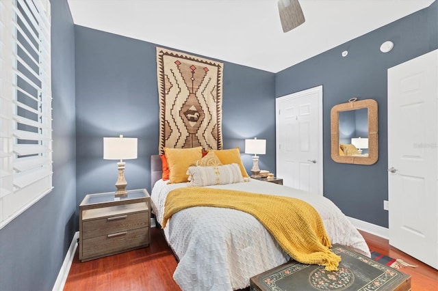 bedroom with dark hardwood / wood-style floors and ceiling fan