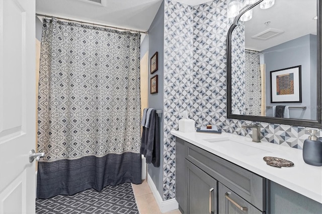 bathroom featuring vanity, tile patterned flooring, and backsplash