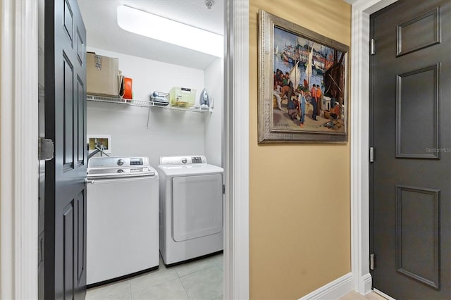 clothes washing area featuring separate washer and dryer and light tile patterned floors