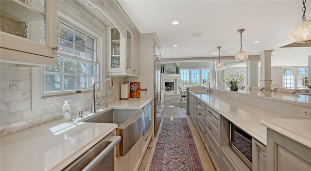 4473 Gulf Of Mexico Dr, Longboat Key, FL 34228 - kitchen with open floor plan, ornate columns, a sink, backsplash, and light countertops